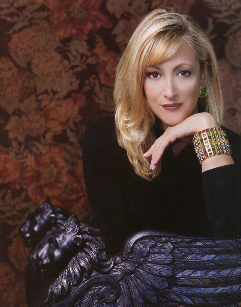 A photograph of Laura Munder wearing wide multicolor sugarloaf bracelet from her collection
