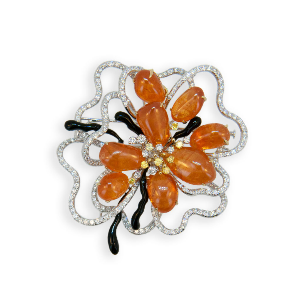 18 karat white and yellow gold brooch set with eight freeform tumble polished Mandarin Garnets 84.25 carats total weight. 214 Round Diamonds 3.07carat total weight. 8 yellow diamonds .40 carats total weight and five onyx and black enamel freeform pieces.