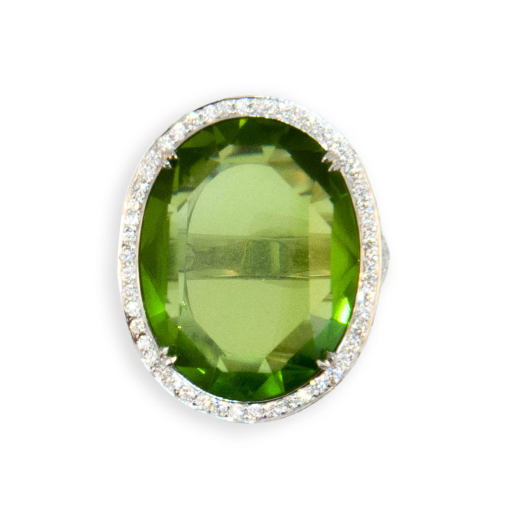 18 karat white gold ring set with one oval faceted Peridot 27.44 carats, no culet, table like facet on both sides. Bezel, under bezel and partial shank are pave' and microset with 222 diamonds 2.87 carats total weight.