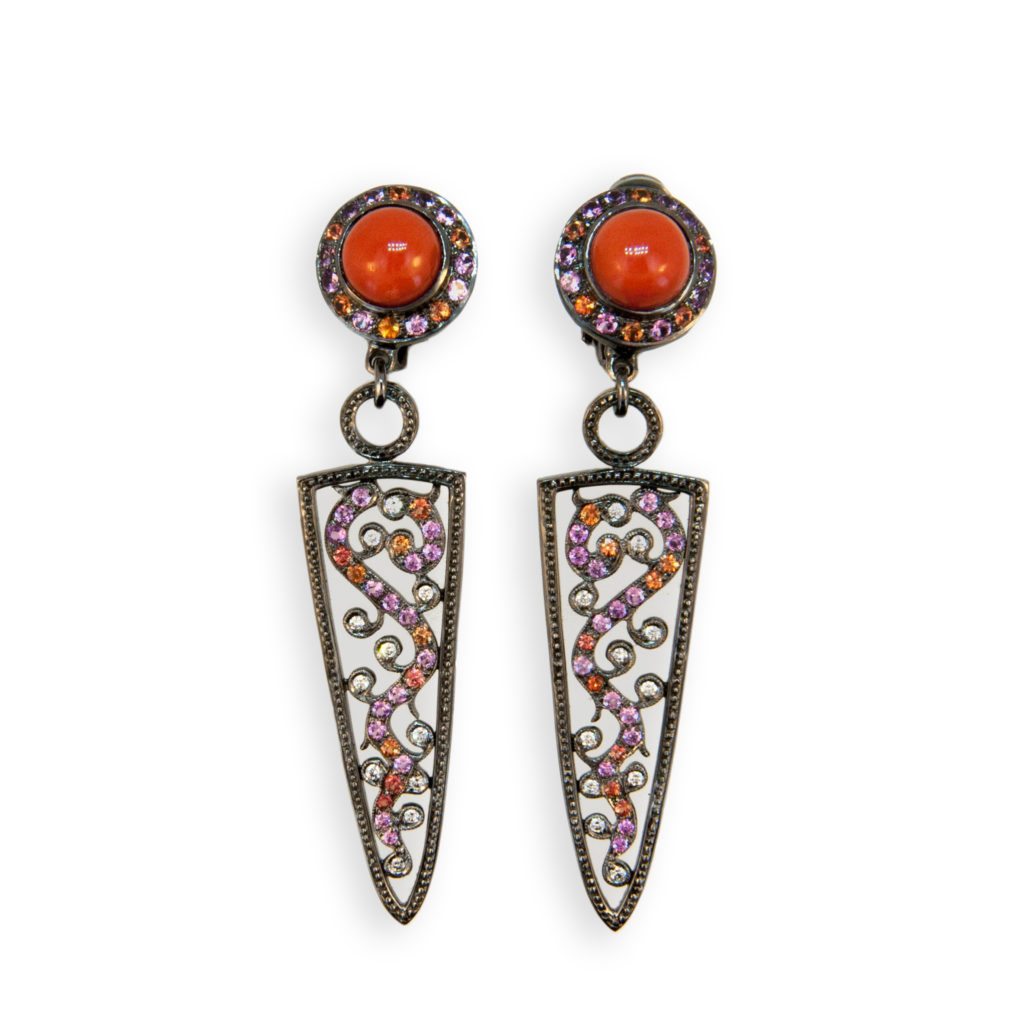 18 karat white gold blackened earrings each set with 8 mm round red cabochon coral weighing approx. 3.78 carats total weight, (52) pink sapphires weighing approximately 1.18 carats total weight, (30) orange sapphires weighing approximately .62 carats total weight 1.3 to 1.4 mm and (22) diamonds 1.2 to 1.3 mm weighing approx. .19 carat total weight.