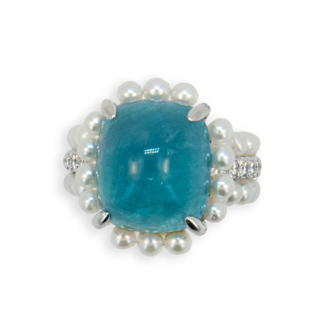 18 karat white gold ring set with one cabochon antique cushion cut Paraiba Tourmaline 11.99 carats (54) cultured Pearls are set surrounding Paraiba at base and in two outer rows of shank (51) round Diamonds are set on four prongs and in center row of shank .57 carat total weight. Size 6 with horseshoe.
