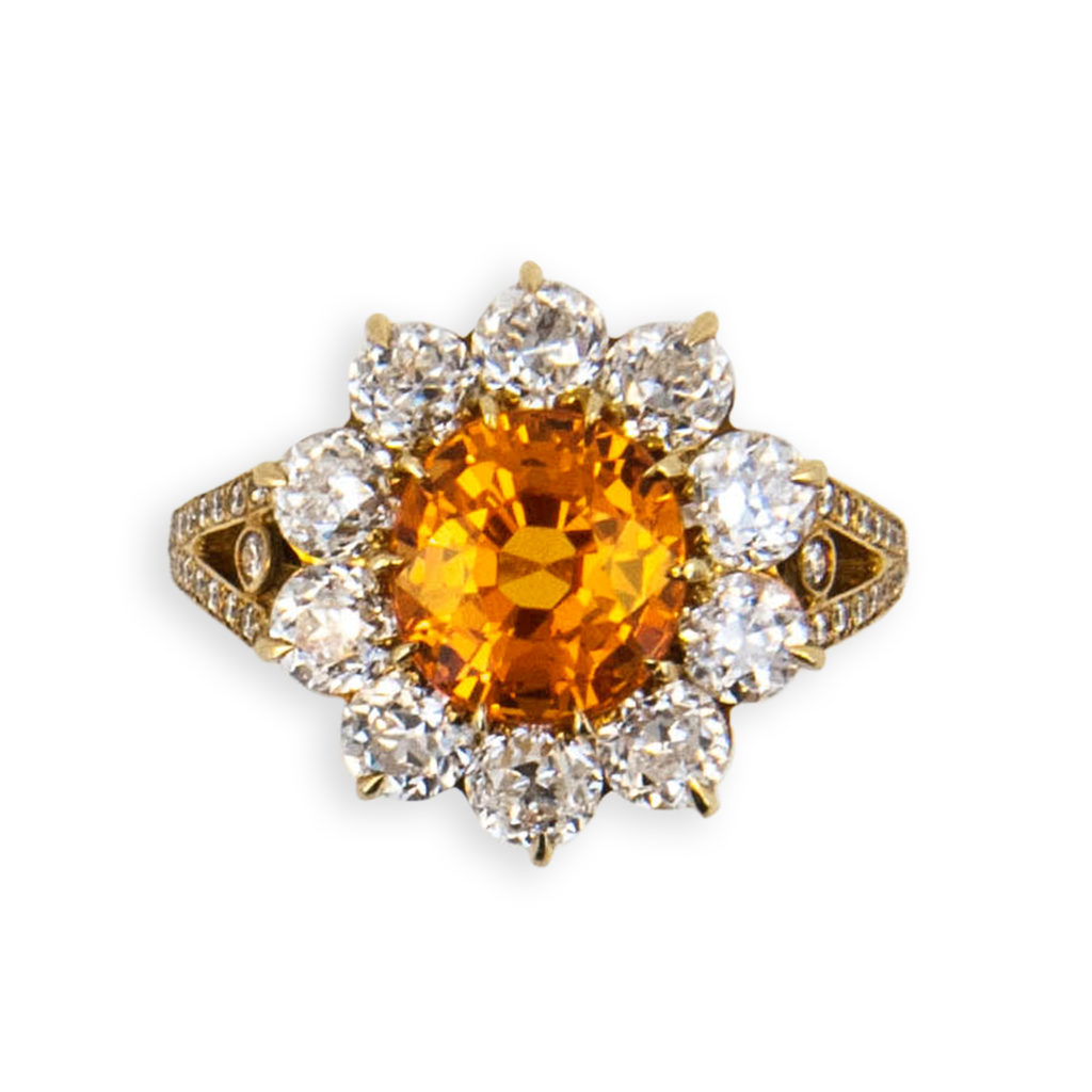 18 karat yellow gold ring set with one slightly ovalish faceted antique style cut Mandarin Garnet 4.47 carats total weight (10) 3.6 mm Mine cut Diamonds 3.04 carats total weight and (58) .9 to 1.5 mm round Diamonds .25 carat total weight Size 6 3/4 with a horseshoe.