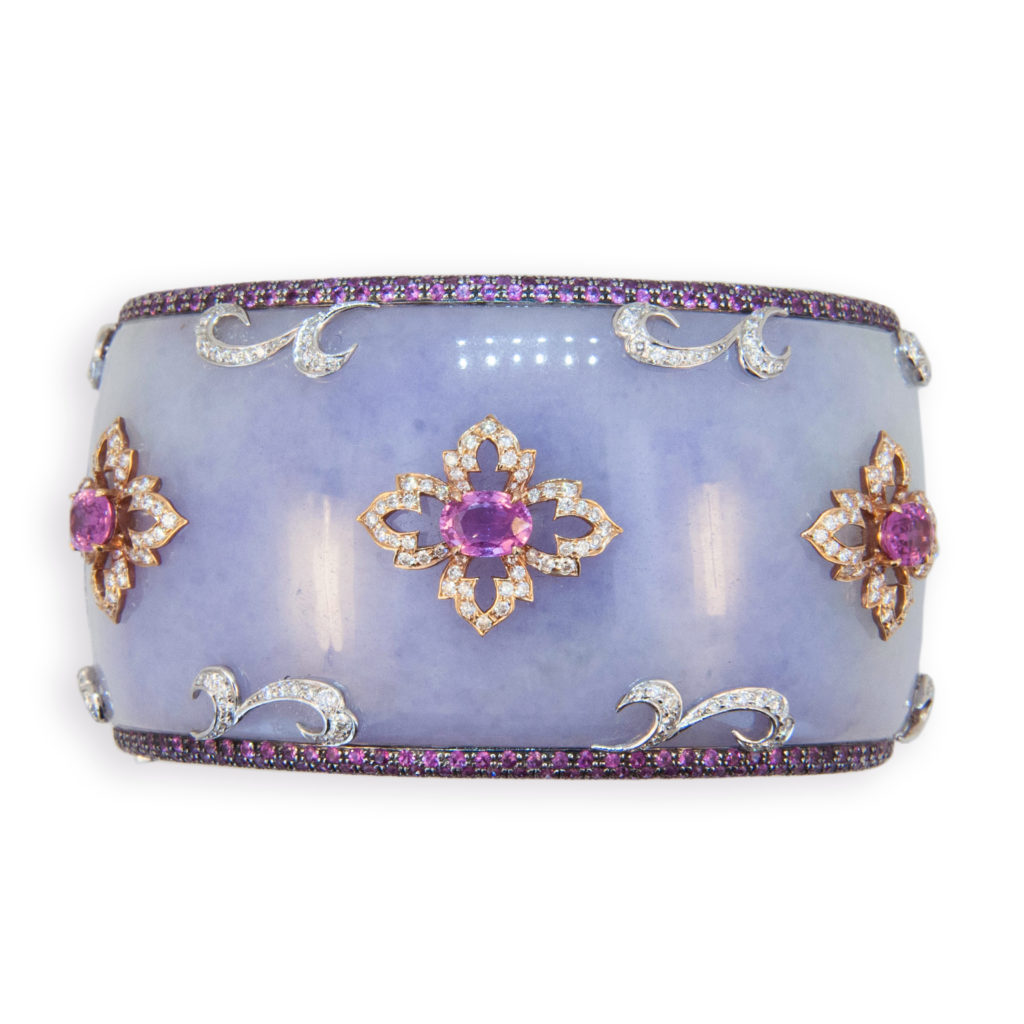 18 karat rose and white gold hinged bangle bracelet, half Lavender Jade, half Grenadill wood, 1 1/2 inches wide with pave' pink sapphire edge 601 pink sapphires 8.52 carats total weight. Lavender Jade is set with three oval pink sapphires (3) 3.02 carats total weight and 336 round diamonds are set in rose gold design surrounding three oval sapphires and in white gold design near pave' edge 2.21 carats total weight.