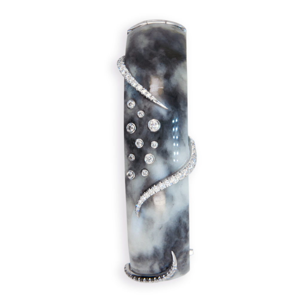 18 karat white gold on Zebra Jade bracelet 5/8 inches wide three swirl designs are set with (47) round diamonds and (10) various size diamonds are tube set, total weight of (57) diamonds is 1.07 carats total weight.