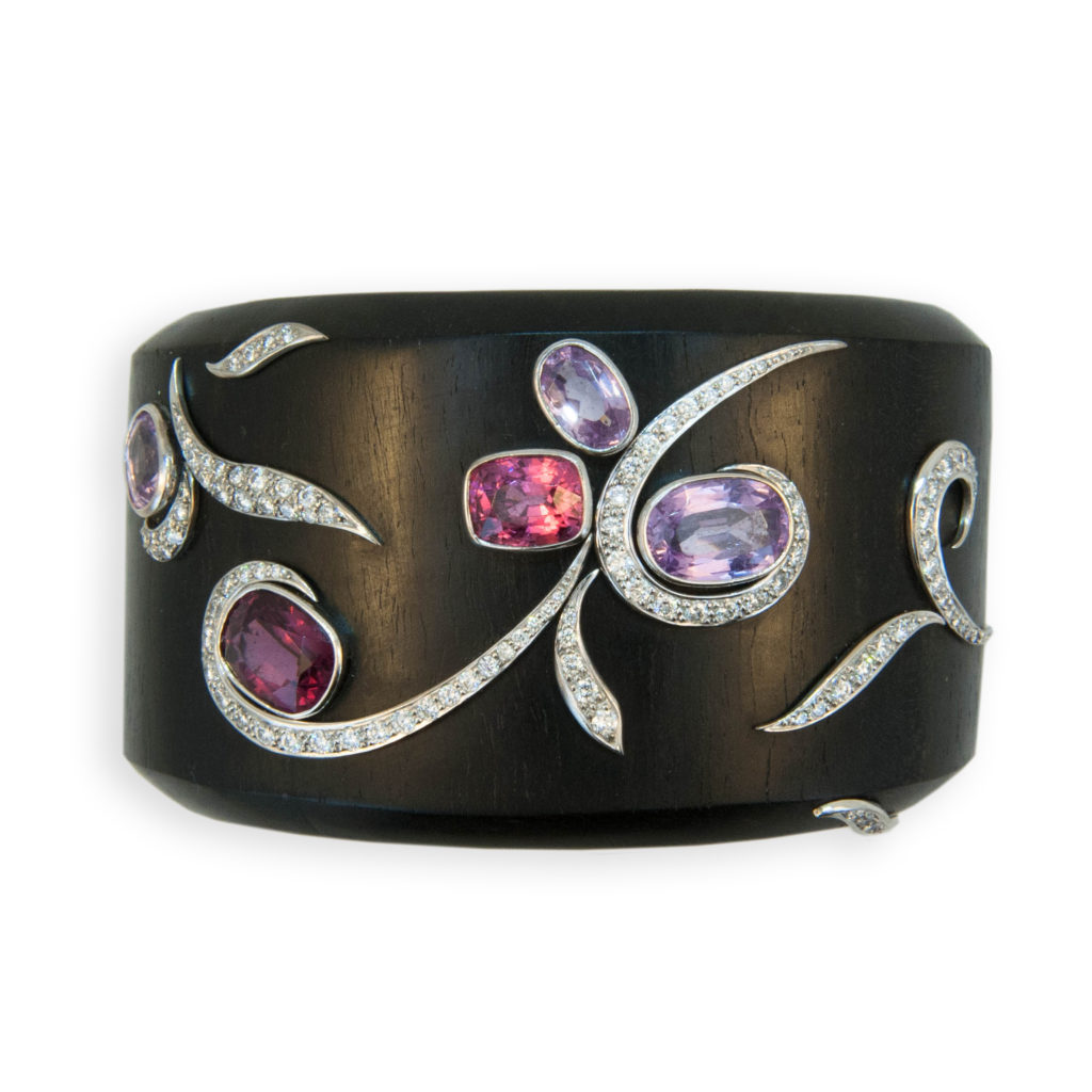 18 karat white gold and wood cuff bracelet set with five cushion/oval multi-color Spinels (light/dark pink and light purple) 11.94 carats total weight. Curved white gold strips set with 106 Diamonds 1.65 carats total weight.