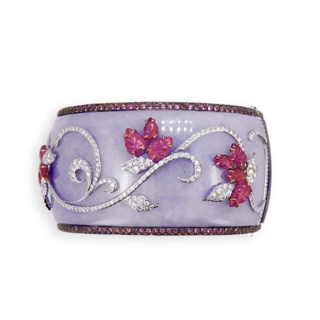 18 karat rose and white gold and blackened white gold hinged bangle bracelet, half Lavender Jade, half Grenadill wood 1.5 inches wide with pave pink sapphire edge 598 pink sapphires 8.77 carats total weight. Lavender Jade is set with 10 carved Ruby leaves 8.61 carats total weight and 293 round diamonds are set in a raised swirl and leaf pattern 2.86 carats total weight.