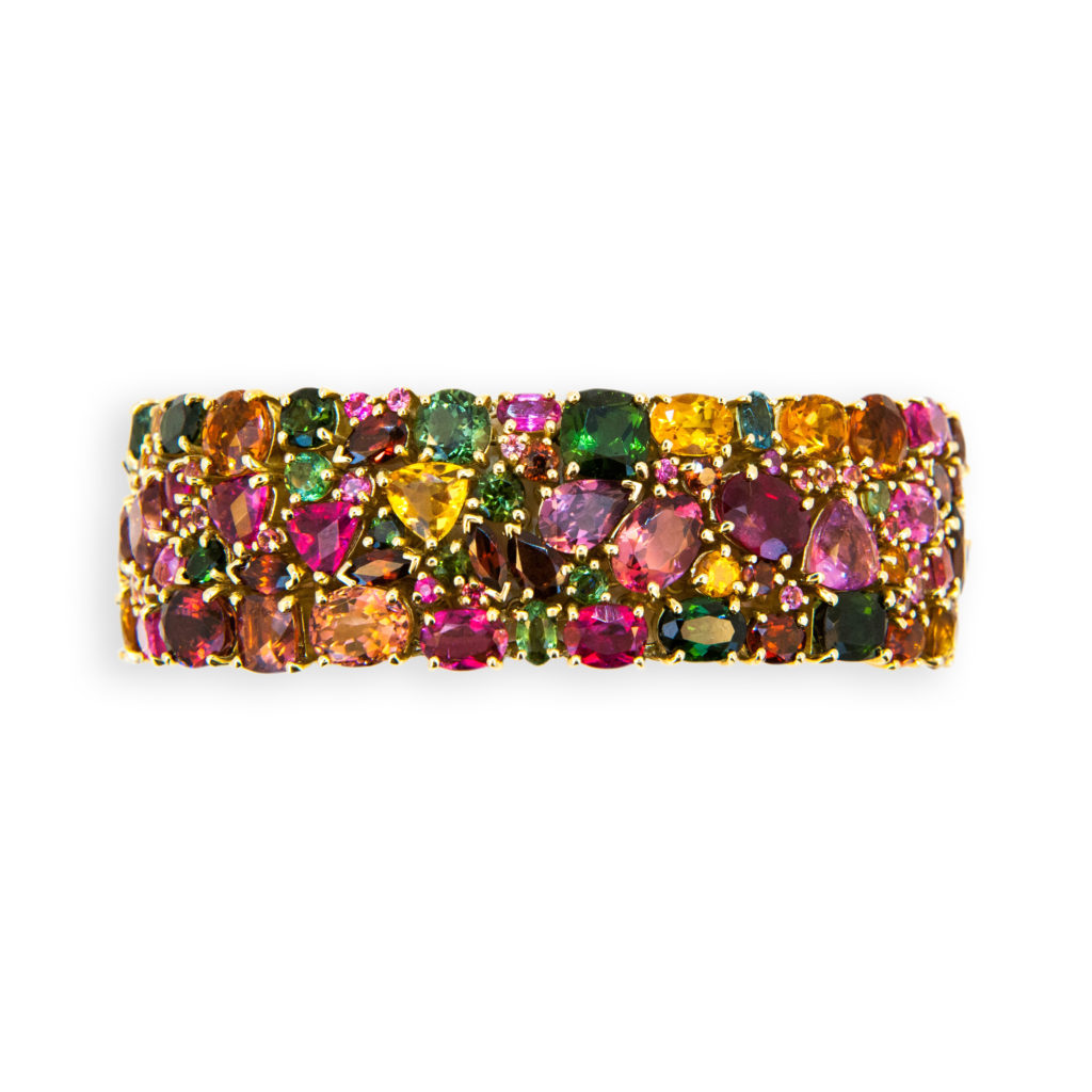 18 karat yellow gold Kaleidoscope bracelet Autumn 188 multi-colored multi-shaped Tourmaline, Garnet, Citrine, and Pink Sapphire 89.33 carats total weight. Oval,round,trillion,marquise, baguette, pear,rectangular. Slightly over 3/4 inches wide. Seven inches long.