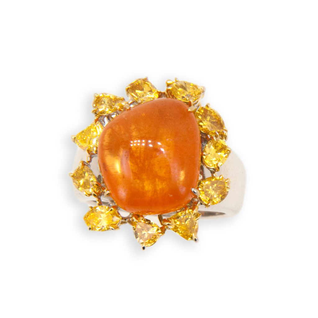 18 karat yellow and white gold ring set with freeform tumble polished Mandarin Garnet 24.05 carats total weight. (11) Fancy shaped yellow diamonds 2.65 carats total weight. Ring is size 7.75 with a horseshoe.