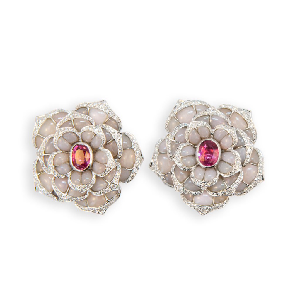 18 karat white gold flower shaped earrings set with (35) pieces of Pink Opal in each earring (70) total. Edges of petals are set with 150 round Diamonds .97 carat total weight and center of each flower is set with one Pink Spinel (2) 1.51 carats total weight. All weights are approximate. Can be worn as clips or with posts.
