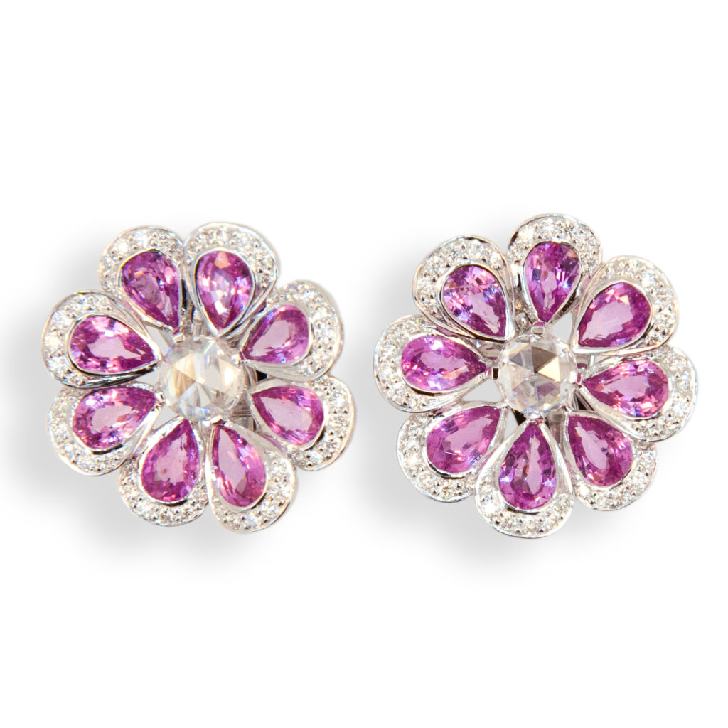 18 karat white gold earrings flower shape set with (16) pear shaped Pink Sapphires 7.73 carats total weight. Center is set with one rose cut diamond (2) .74 carat total weight. Edges of petals are set with (96) Diamonds .69 carat total weight. Can be worn as pierced or clip on, posts fold down