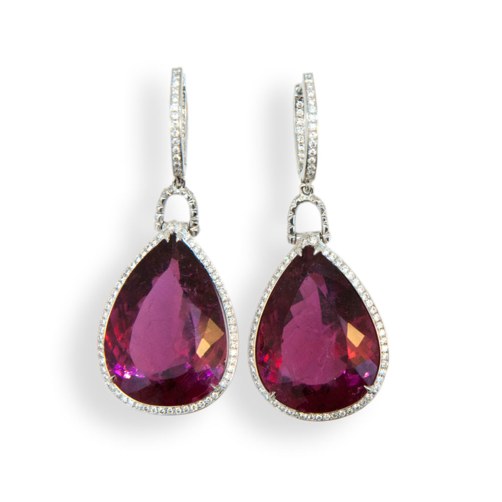 18 karat white gold earrings each set with one faceted pear shaped Rubellite Tourmaline 15.80 carats and 15.65 carats. Diamond hoop is set with (23) diamonds (46) total .19 carat total weight each connecting link is set with (8) diamonds (16) total .14 carat total weight. Surrounding Rubellite are micro-set diamonds (59) and (56), 115 total .31 carat total weight.