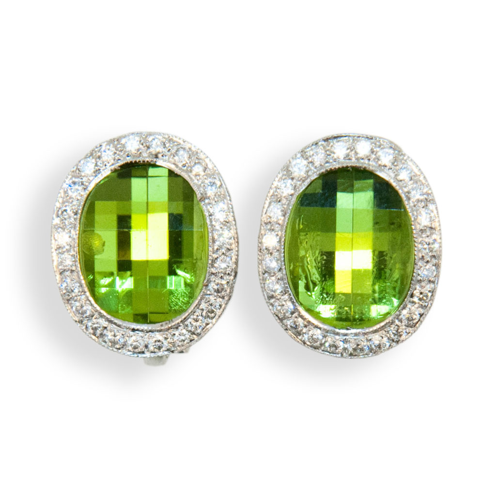18 karat white gold oval checker cut peridot earrings surrounded by diamonds. Peridot are 8.65 carats total weight and diamonds 1.20 carats total weight. Earrings are clip on, posts could be added.